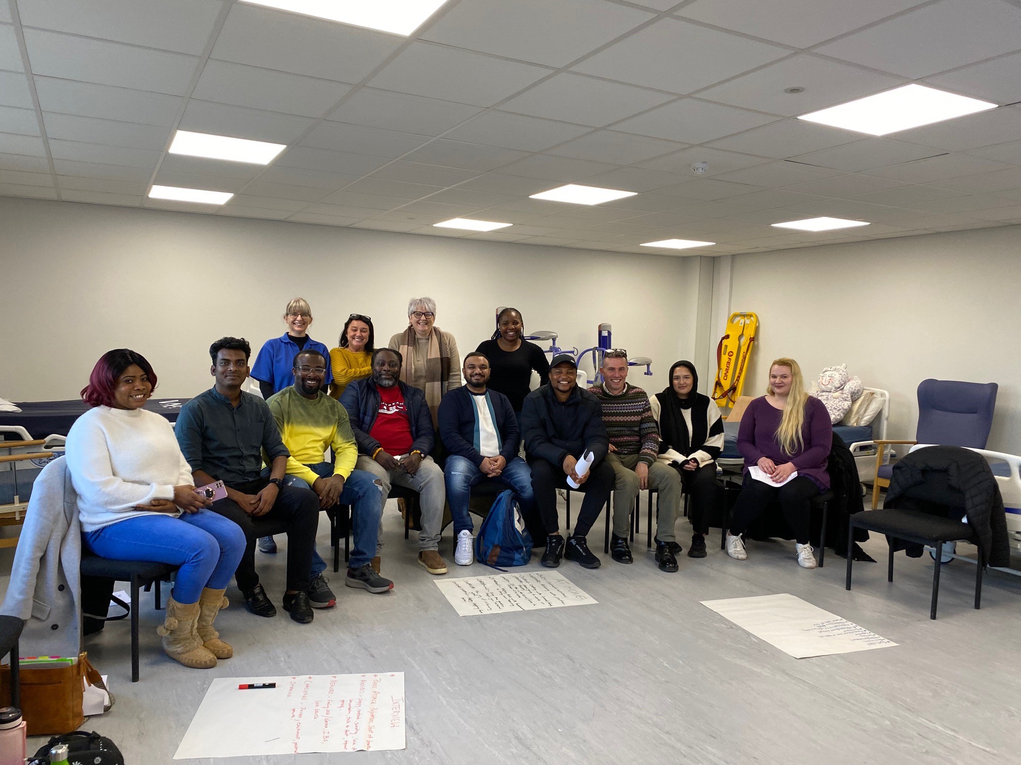 Group of people sat in a semi circle. They are taking part in training for their new roles.