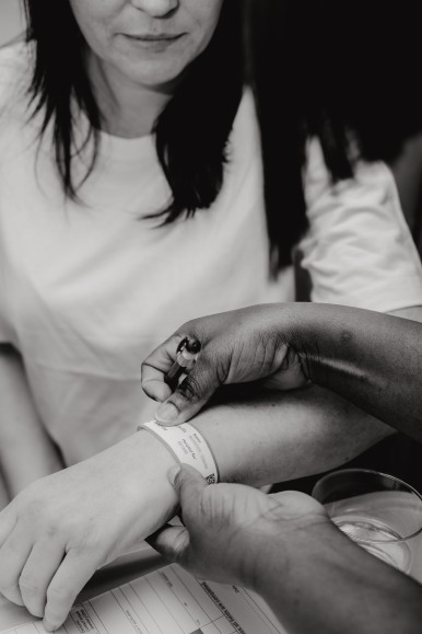 black and white image of nurse putting hospital band on patient's wrist