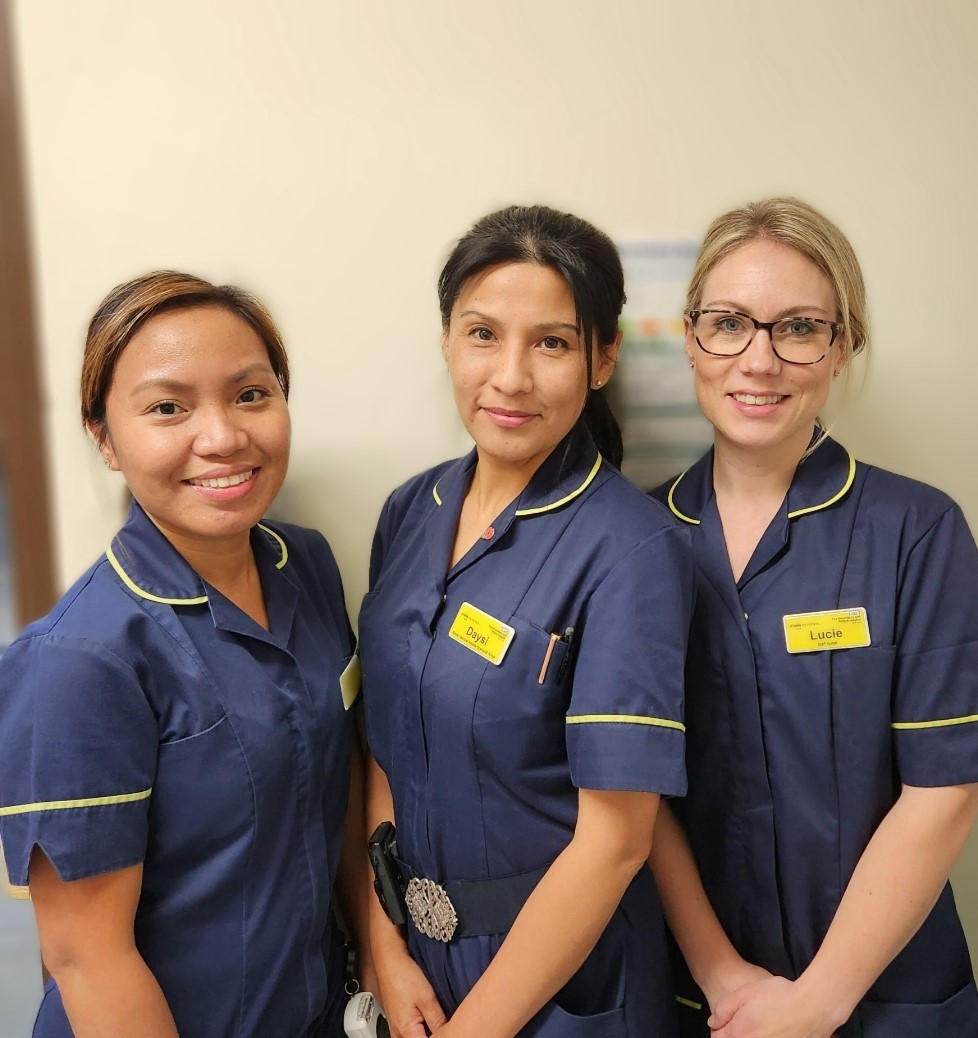 three nurses in uniform, smiling