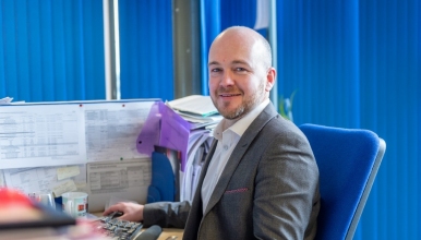 man wearing suit sat at desk
