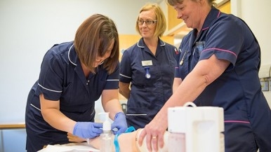 Nurses at Princes Royal Hospital training how to cannulate on a dummy